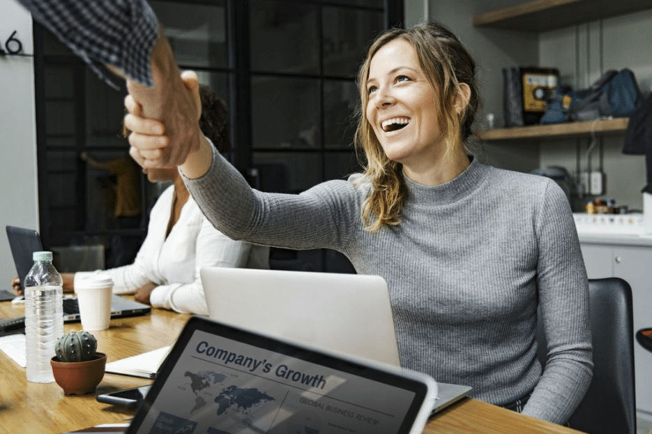 A woman receives a handshake for successfully using ego bait content on her company’s site.